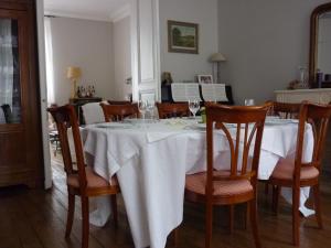 een eetkamer met een witte tafel en stoelen bij Chambres d'Hôtes Les Jardins de la Cathédrale in Angoulême +22 foto's