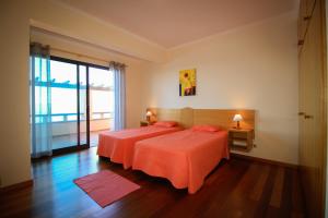 ポルト・モニスにあるParadise Ocean View by AnaLodgesのベッドルーム1室(ベッド2台、大きな窓付)