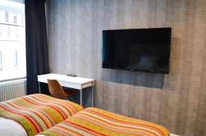 a hotel room with a flat screen tv on a wall at Hotell Stortorget, Östersund in Östersund