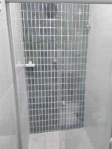 um chuveiro com uma porta de vidro na casa de banho em Pousada Beira Mar no Recife