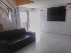 a living room with a couch and a flat screen tv at Pousada Beira Mar in Recife