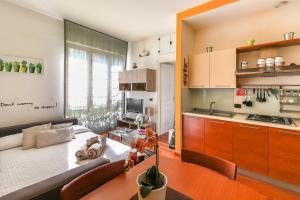 ミラノにあるAlessia's Flat- Lorenteggioのキッチン、リビングルーム(テーブル付)が備わります。