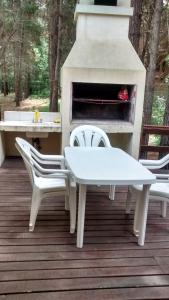 a table and chairs on a deck with a fireplace at Ñande Roga in Mar de las Pampas +7 photos