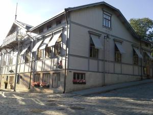 a large white building with windows on a street at Cafe-Restaurant & Hotel Saima in Savonlinna