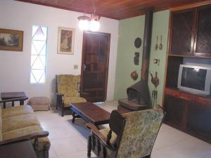 a living room with a fireplace and a tv at Casa em Passa Quatro in Passa Quatro