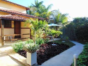 un jardin avec des palmiers en face d'une maison dans l'établissement Apartamentos Portal da Ferradura, à Búzios