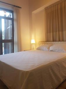 a bedroom with a large white bed with a window at Kalopanayiotis Museum Inn in Kalopanayiotis
