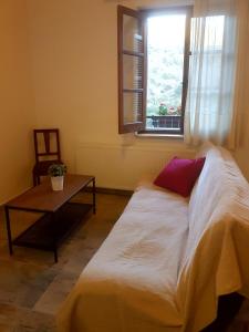 a bed in a room with a table and a window at Kalopanayiotis Museum Studio in Kalopanayiotis