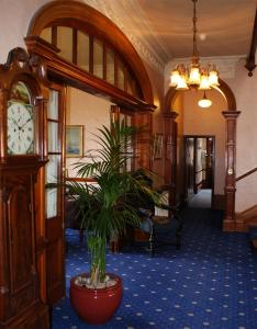 a room with a grandfather clock and a potted plant at Ramnee Hotel in Forres