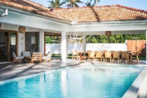 a patio with a table and chairs next to a swimming pool at Tea Tree Villa in Ahangama