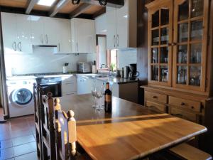 una cocina con una mesa de madera y una botella de vino en Casa Rural Rudron, en Valdelateja
