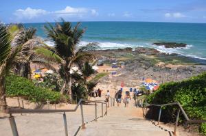 un grupo de personas caminando por las escaleras hasta la playa en 3 Quartos na Praia do Buracão - Rio Vermelho, en Salvador