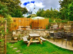 a backyard with a wooden table and a stone wall at The Boathouse in Anstruther
