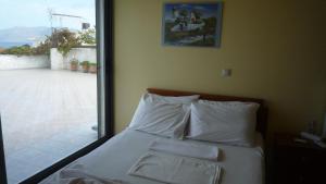 a bed with white pillows in a room with a window at Hostel Stylianos Kissamos in Kissamos