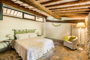 a bedroom with a bed and a chair at Ripostena in Casole dʼElsa