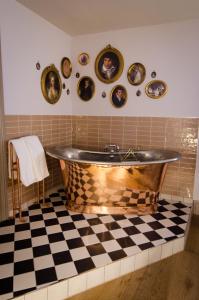 a bath tub in a bathroom with a checkered floor at 1777. At The Albion in Wimborne Minster