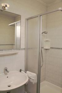 La salle de bains est pourvue d'une douche, d'un lavabo et d'une baignoire. dans l'établissement Beim Gangl, à Illmitz