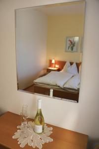 una botella de vino en una mesa frente a un espejo en Beim Gangl, en Illmitz