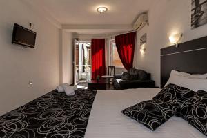 a hotel room with a large bed and a chair at Villa Veron in Ohrid