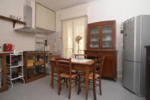 een keuken met een tafel en stoelen en een koelkast bij L'incrocio - Bed&Breakfast in Imola