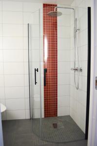 a shower with a glass door and red tile at Hotell Stortorget, Östersund in Östersund +5 photos
