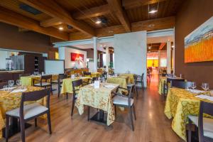 restauracja ze stołami i krzesłami z żółtą tkaniną w obiekcie Hotel Viest w mieście Vicenza