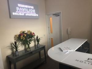 un bureau avec une table et des fleurs sur elle dans l'établissement Pavilion Holiday Apartments, à Weston-super-Mare