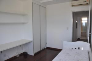 a room with white walls and a table and a chair at 3 Quartos na Praia do Buracão - Rio Vermelho in Salvador