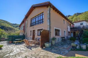 Casa con patio con mesa y sillas en Apartamentos Rurales Balcón Real Senda del Oso, en Campiello