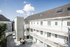 スタヴァンゲルにあるStavanger Housing Hotelの白いバルコニーと灰色の屋根が特徴のアパートメントです。