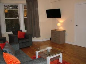 uma sala de estar com um sofá e uma televisão em Stratford Apartment em Newmarket