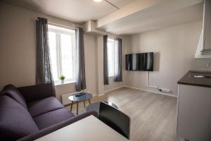 a living room with a couch and a tv at Stavanger Housing Hotel in Stavanger