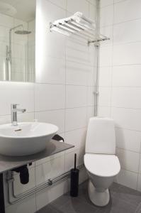 a white bathroom with a toilet and a sink at Hotell Stortorget, Östersund in Östersund
