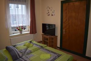 Schlafzimmer mit einem Bett und einem Flachbild-TV in der Unterkunft Privatzimmer in Krefeld