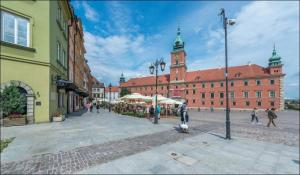 a city street with buildings and people walking around at P&O Apartments Piwna in Warsaw