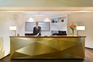 a man standing in front of a counter in a room at Hotel City Zürich Design & Lifestyle in Zurich