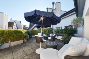 a patio with couches and an umbrella at Hotel City Zürich Design & Lifestyle in Zürich