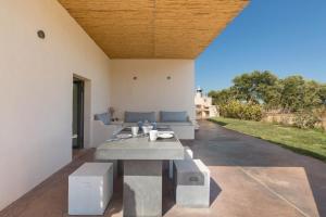 a room with a table and a couch in a house at Casale Cimino by BarbarHouse in Ostuni