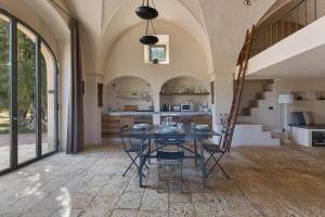 een keuken en eetkamer met een tafel en stoelen bij Casale Cimino by BarbarHouse in Ostuni