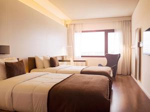 Esplendor by Wyndham Asuncion tesisinde bir odada yatak veya yataklar