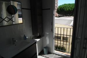 baño con lavabo y vistas a un balcón en Appartement en Saint Cyprien Plage