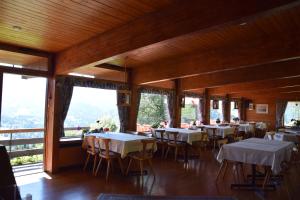 een eetkamer met tafels, stoelen en ramen bij Gasthof Hotel IFENBLICK in Sibratsgfäll