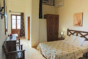 1 dormitorio con 1 cama y puerta de madera en Hotel Rural Hoyo Bautista en Martín de la Jara
