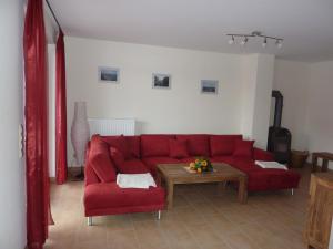 uma sala de estar com um sofá vermelho e uma mesa em Ferienhaus NEMO em Rerik