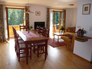 a dining room with a table and chairs and a living room at Eisenhof apartments in Altenmarkt im Pongau