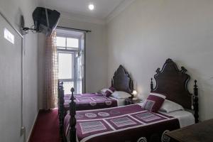 two beds in a bedroom with a window at Veneza in Porto