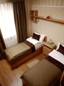 a hotel room with two beds and a window at Leon Hotel in Lviv