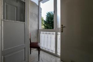 una puerta abierta con una silla junto a una ventana en Veneza, en Oporto