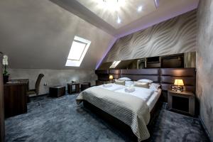 um quarto com uma cama grande e uma clarabóia em Royal Apartments Hotel Kecskemét em Kecskemét