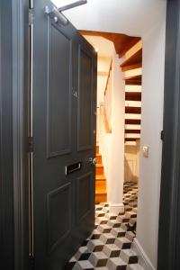 a hallway with a black door and a checkered floor at 27/3a Cockburn Street Apartments in Edinburgh